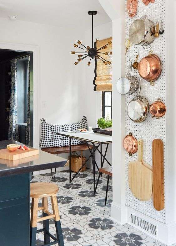 pots and pans stored on a pegboard in small kitchen